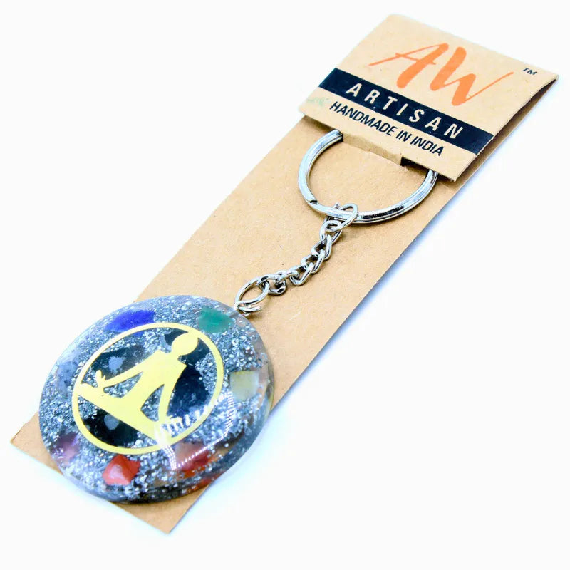 Porte-clés en orgonite artisanale avec symbole Bouddha et inclusions de pierres semi-précieuses.