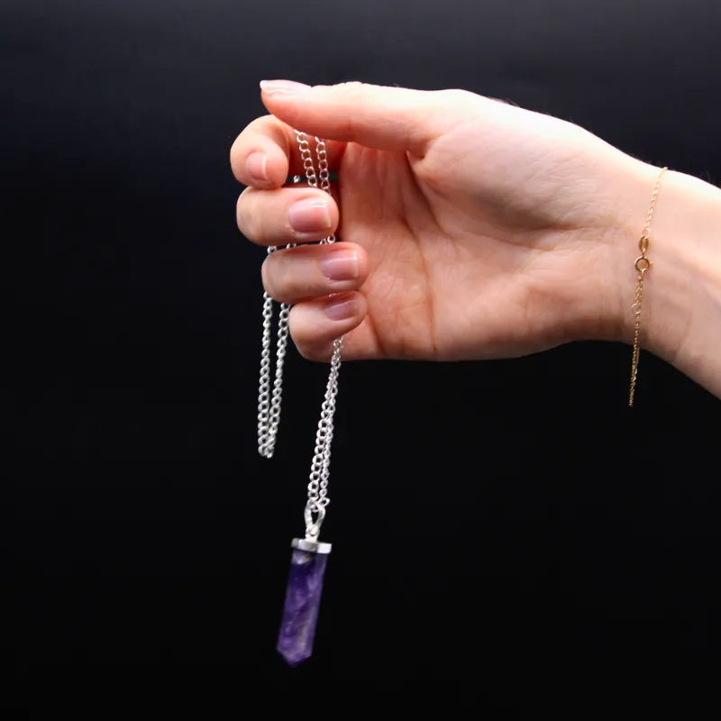 Pendentif en cristaux d'Améthyste naturel tenu en mains